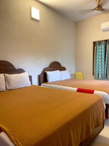a hotel room with two beds and a window at Farmdean holiday home in Kovakulam