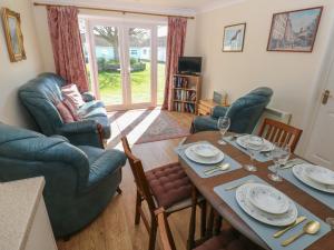 a living room with a dining room table and chairs at Kites - 52 Gower Holiday Village in Swansea