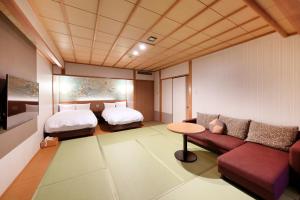 una camera d'albergo con un divano e un letto di Yukibou Hakusen a Yonago