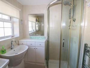 a bathroom with a sink and a shower at Kites - 52 Gower Holiday Village in Swansea +11 photos