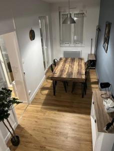 a dining room with a wooden table and chairs at Le voyageur - Appartement Hyper Centre in Cambrai +1 photo