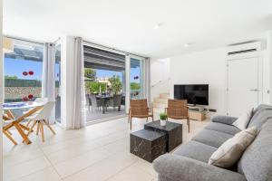 un soggiorno con un divano, una televisione e un tavolo di Luxury Villa - Amazing Sea Views a Son Bou Altre 38 foto