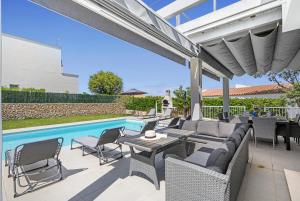 un patio con tavolo e sedie e una piscina di Luxury Villa - Amazing Sea Views a Son Bou