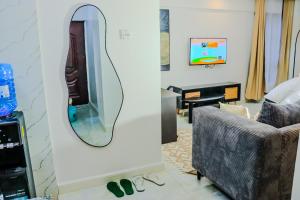 a living room with a mirror and a chair at Elegant & Stylish Appartments In Nairobi Kileleshwa in Nairobi