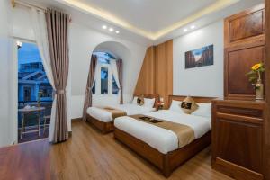 a hotel room with two beds and a balcony at Pho Hoa Hotel in Da Lat