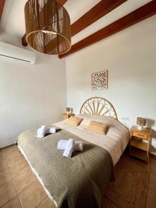 a bedroom with a large bed with two towels at Kasa K - Slowlife in Binibeca in Binibeca +40 photos