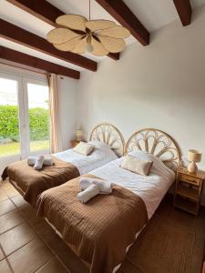 two beds in a bedroom with a ceiling fan at Kasa K - Slowlife in Binibeca in Binibeca