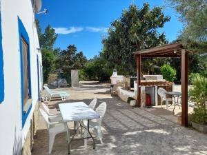 a patio with chairs and a table and a grill at Quinta do Pomarinho with private pool in Tavira