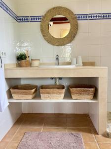 a bathroom with a sink and a mirror and baskets at Kasa K - Slowlife in Binibeca in Binibeca