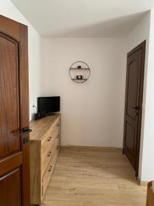 a living room with a tv and a wooden dresser at Pensiunea Margareta corp A, Ceahlau in Ceahlău