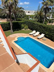 a swimming pool with two loungers and a resort at Kasa K - Slowlife in Binibeca in Binibeca