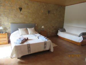 a bedroom with two beds and a stone wall at Quinta do Pomarinho with private pool in Tavira +15 photos