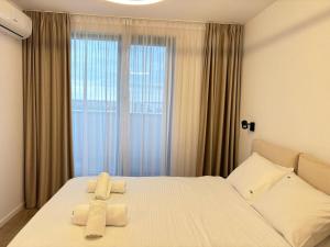 a bedroom with a bed with two towels on it at H Pipera - 2BR - Lake View in Voluntari