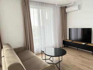a living room with a couch and a table at H Pipera - 2BR - Lake View in Voluntari