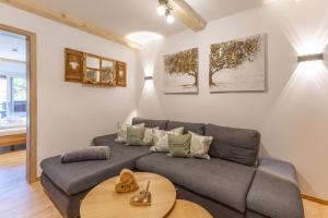 una sala de estar con un sofá y una mesa en DeLuxe Wohnung am Tegernsee Gschwandtnerhof, en Festenbach