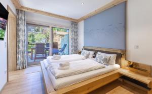 Un dormitorio con dos camas y una gran ventana. en DeLuxe Wohnung am Tegernsee Gschwandtnerhof, en Festenbach 35 fotos más