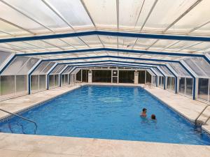 a swimming pool with two people in the water at ATICO DELUXE JACUZZI La Cala BENIDORM in Benidorm
