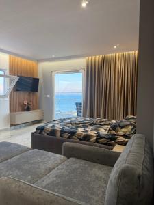 a bedroom with two beds and a large window at Eri Apartments in Durrës