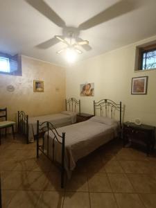 ジノーザ・マリーナにあるCasa al Mareのベッド2台と天井ファン付きの寝室