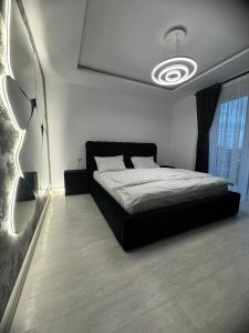 ラダウツィにあるEuro Apartments Radautiのベッドルーム(黒いベッド1台、大きな窓付)