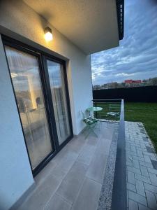 ラダウツィにあるEuro Apartments Radautiの家の中のパティオ(テーブル、椅子付)