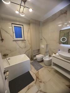 ラダウツィにあるEuro Apartments Radautiの洗面台、浴槽、トイレを備えたバスルーム