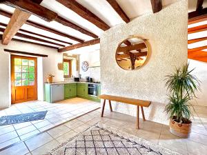a kitchen with a table and a mirror on the wall at Grange authentique avec vue, piscine chauffée et Wifi in Daglan
