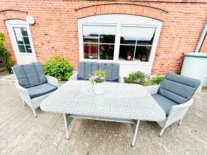 费马恩Ferienhof Eckhoff的一张白色的桌子和两把椅子以及一张带鲜花的桌子