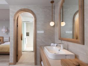 a bathroom with a sink and a mirror and a bed at LIUBAI CUNSHU Seaview Resort Hotel in Dali Shuanglang