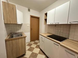 a kitchen with white cabinets and a sink at Apartma Studio Enej Piran in Piran