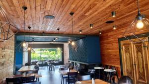 a restaurant with wooden ceilings and tables and chairs at Cha-lu-pa in Loučná nad Desnou
