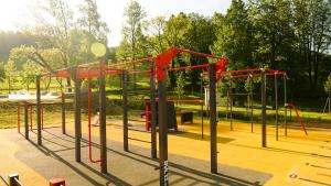 a playground with red equipment in a park at Cha-lu-pa in Loučná nad Desnou