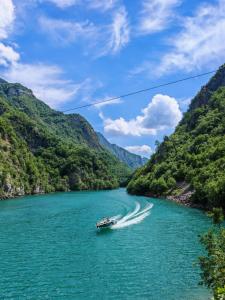 a boat on the river in a mountain valley at Riverside Komani Lake in Koman