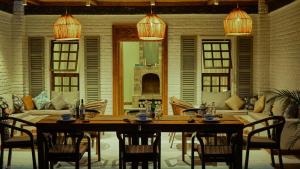 a dining room with a table and chairs and a couch at Mateves boutique lodge in Arusha