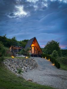 a log cabin with lights on a gravel road at A FRAME 1 TRANSALPINA in Petreşti