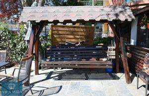 a wooden bench with an awning on a patio at Mida Summer Villa in Mamaia Sat/Năvodari