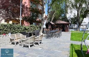 a group of chairs and tables on a patio at Mida Summer Villa in Mamaia Sat/Năvodari +28 photos
