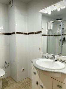 un bagno con lavandino, specchio e WC di Apartamentos La Muela - Chulilla a Chulilla Altre 34 foto