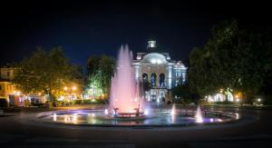 a water fountain in front of a building at night at Serene Luxe Oasis Retreat on the Outskirts by Flat Mаnager in Plovdiv +53 photos