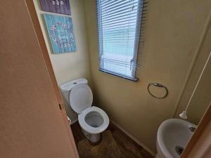 a bathroom with a toilet and a sink at Caravan Meg 3 bed robin holiday in Rhyl +17 photos