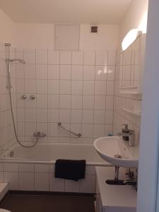 メンヒェングラートバッハにあるZentrales Apartment für Monteureの浴槽、洗面台、シャワーを備えたバスルーム