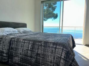 a bedroom with a bed with a large window at L'Íle D'Azur in Arenzano