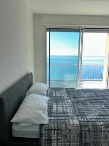 a bedroom with a bed with a view of the ocean at L'Íle D'Azur in Arenzano