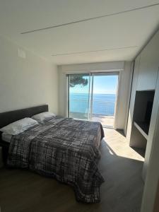 a bedroom with a bed and a view of the ocean at L'Íle D'Azur in Arenzano