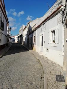eine leere Straße in einer Stadt mit weißen Gebäuden in der Unterkunft A Casa da Vila in Alcochete + 52 Fotos