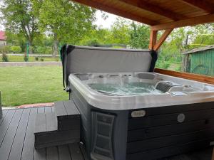a hot tub sitting on a deck with at Izabella Apartman Bogács in Bogács