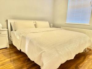 a white bed in a bedroom with a window at The Urban Oasis - Great location near Pubs, Restaurants and more! Bus links on doorstep in Belfast +16 photos