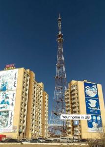 a christmas tree in the middle of two buildings at Your home in Ulaanbaatar in Ulaanbaatar