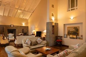 a living room with couches and a fireplace at Grand Bungalow Nuwara Eliya by Seven Angels in Nuwara Eliya
