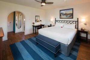 a bedroom with a large white bed and a blue rug at The Milo in Santa Barbara